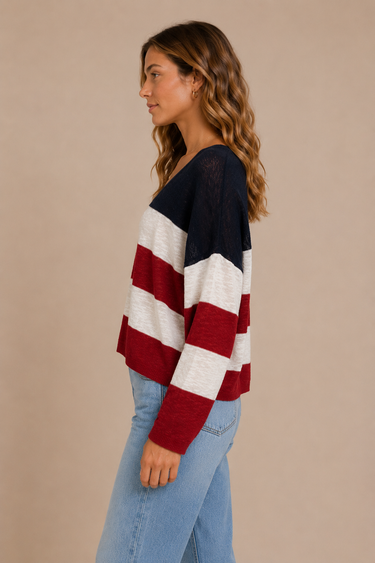 Woman wearing a red, white, and blue striped sweater against a beige background