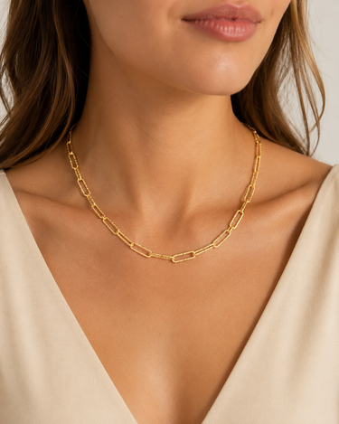 a woman wearing a hammered paper clip gold-plated necklace.