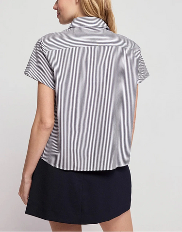 Woman wearing a black and white striped shirt with short sleeves on a plain background
