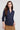 Woman wearing a navy blue shirt with a plain background