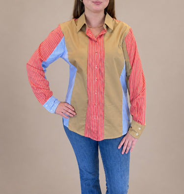 Person wearing a colorful shirt with a beige vest over a red and blue striped shirt, on a beige background.