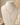 A delicate gold lariat-style necklace with small pearl-like drops and a teardrop-shaped light blue gemstone pendant, displayed on a cream fabric mannequin bust.