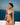 Woman wearing a blue bikini against a clear blue sky and ocean background