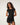 Woman wearing a mesh cover up black dress with a plain background