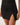 Black mesh ruched bottom of black cover up on a plain background
