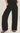 Person wearing black wide-leg pants on a plain background
