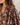 Close-up of a woman wearing a brown bohemian floral print blouse with voluminous sleeves and a V-neckline.