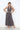 Woman wearing a patterned maxi dress against a white background
