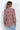 Multicolor abstract print V-neck blouse with long sleeves and button cuffs, styled with light-wash jeans on a model.