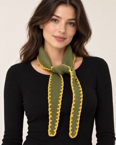 a woman wearing a cashmere dark green knit with yellow-green stitching