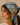 A woman in profile wearing a blue and multicolor printed cotton scarf tied under her head. The scarf features a vintage-style map of Mexico with illustrations of landmarks, desert scenery, and Route 66.
