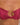 Close-up of a pink bikini top with a gold clasp on a person's torso.