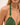 Green bikini top with gold buckle on a plain background