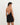 Woman wearing a black dress with an open back on a white background