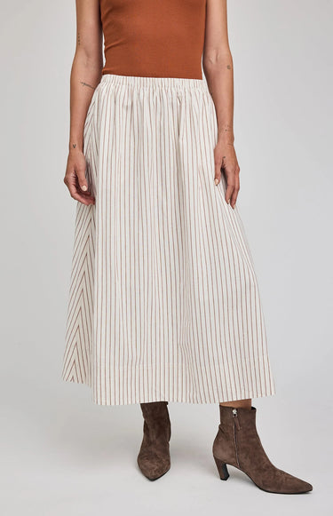 Person wearing a pleated skirt with a plain background