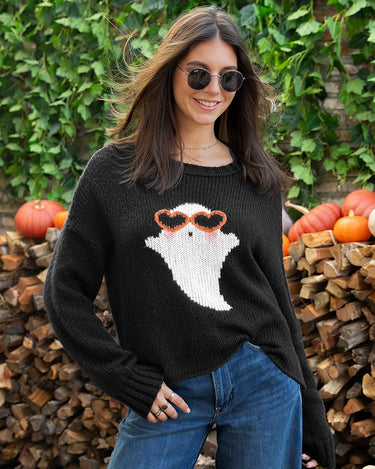 A woman wearing a black knit sweater with a ghost wearing orange heart sunglasses