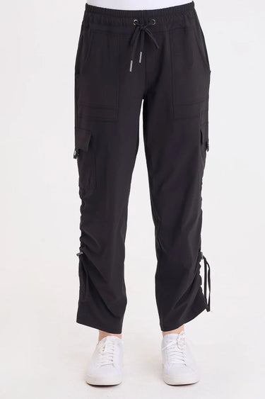 A woman wearing black cargo pants with a cinched detailing on the side of the leg panel.