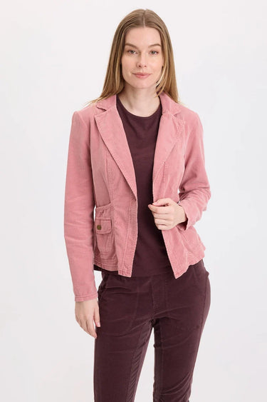 a woman wearing a pink corduroy jacket and berry pants on a white background.