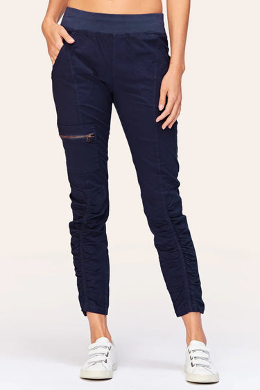 Navy blue jogger pants worn by a person on a white background