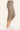 A side view of a person wearing taupe cargo capri pants with ruched details at the hem, paired with white sneakers, against a solid off-white background.