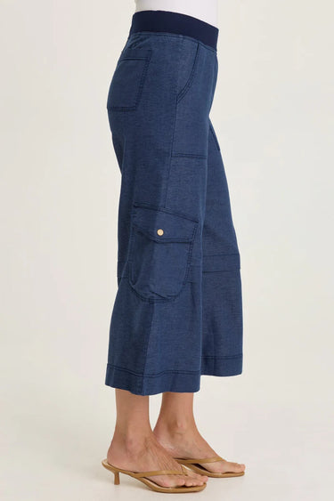 A woman wearing wide-leg cropped gaucho pants in navy on a white background