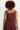 Person wearing a maroon tank top and pants on a white background