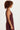 Woman wearing a maroon crochet top and skirt on a light background