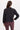 A woman wearing a black active jacket and berry pants on a whit background