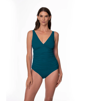 Woman wearing a teal tankini with swimsuit bottoms on a white background