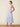 Woman wearing a blue floral dress on a beige background