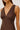 Brown sleeveless top worn by a person on a plain background