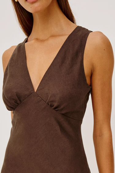 Brown sleeveless top worn by a person on a plain background