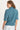 Woman wearing a teal shirt with a white background