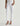 Person wearing white jeans on a plain background