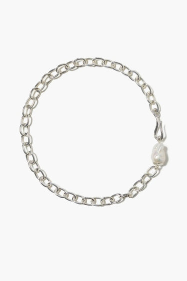 Silver link chain necklace with an irregular freshwater baroque pearl accent, displayed on a white background.