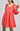 Coral dress with lace details on a gray background