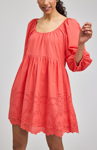 Coral dress with lace details on a gray background
