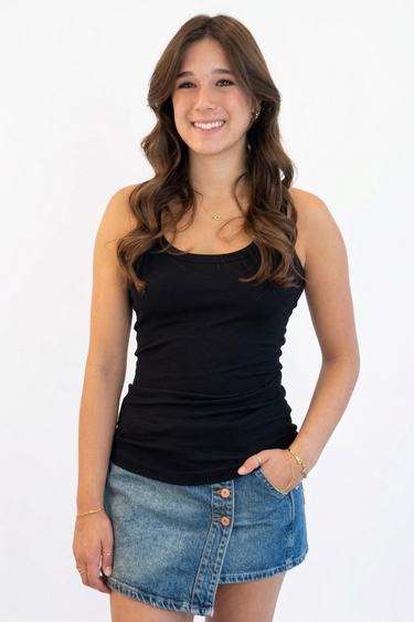 Woman wearing a black tank top and denim skirt on a white background