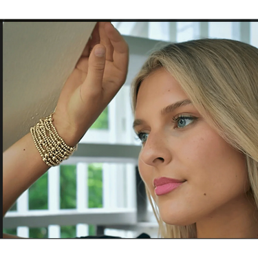A woman wearing a stack of beaded bracelets