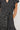 Black dress with white pattern worn by a person on a plain background
