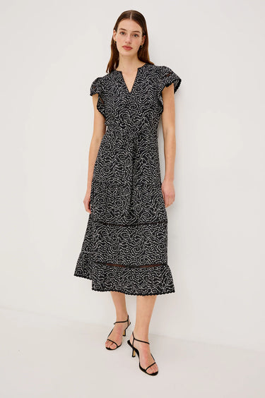 Woman wearing a black and white patterned dress on a white background