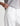 White pants worn by a person on a white background