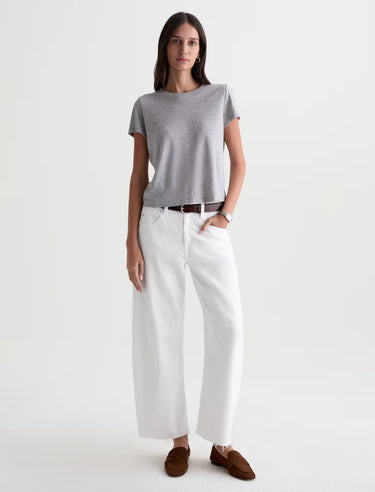 Woman wearing a gray t-shirt and white pants on a white background