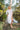 woman wearing the white Eyelet Trim Long White Shirt Dress leaning on a tree