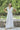 woman wearing a white maxi lace dress in front of a fence