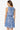 Woman wearing a blue floral dress on a white background