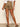 Person wearing brown shorts and black sandals on a neutral background
