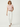 Woman wearing a pink top and white pants on a white background