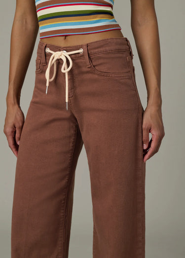 Brown pants with a striped crop top on a neutral background