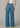 Person wearing blue jeans on a plain background